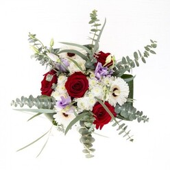 From a sunlit florist studio near the heart of Bankside, this bouquet is expertly crafted to capture both modern sensibilities and timeless grace. A proud core of lush red roses invites the eye with its deep, velvety embrace, surrounded by the bright, open faces of white gerbera daisies whose densely petaled discs evoke both purity and joy. Delicate touches of lilac lisianthus, some tenderly closed, bring a soothing pastel accent and suggest new beginnings-mirroring the gentle optimism that floats along the Thames' banks. Interspersed among these statement blooms, clusters of ivory-hued filler flowers lend the ensemble a softly textured finish reminiscent of morning mist over the river. The arrangement flourishes with abundant eucalyptus, the silver-tinged leaves nestling around the florals and hinting at the wild, aromatic breezes from nearby riverside gardens. Framed by broad green foliage at its base, and poised in a sleek glass vase that exposes the healthy green stems within, this bouquet makes a beautiful impression. Ideal as a gift for anniversaries, celebrations, or gentle sympathy, it embodies the skilled touch of Bankside's expert florists and the welcoming spirit of the neighbourhood.
